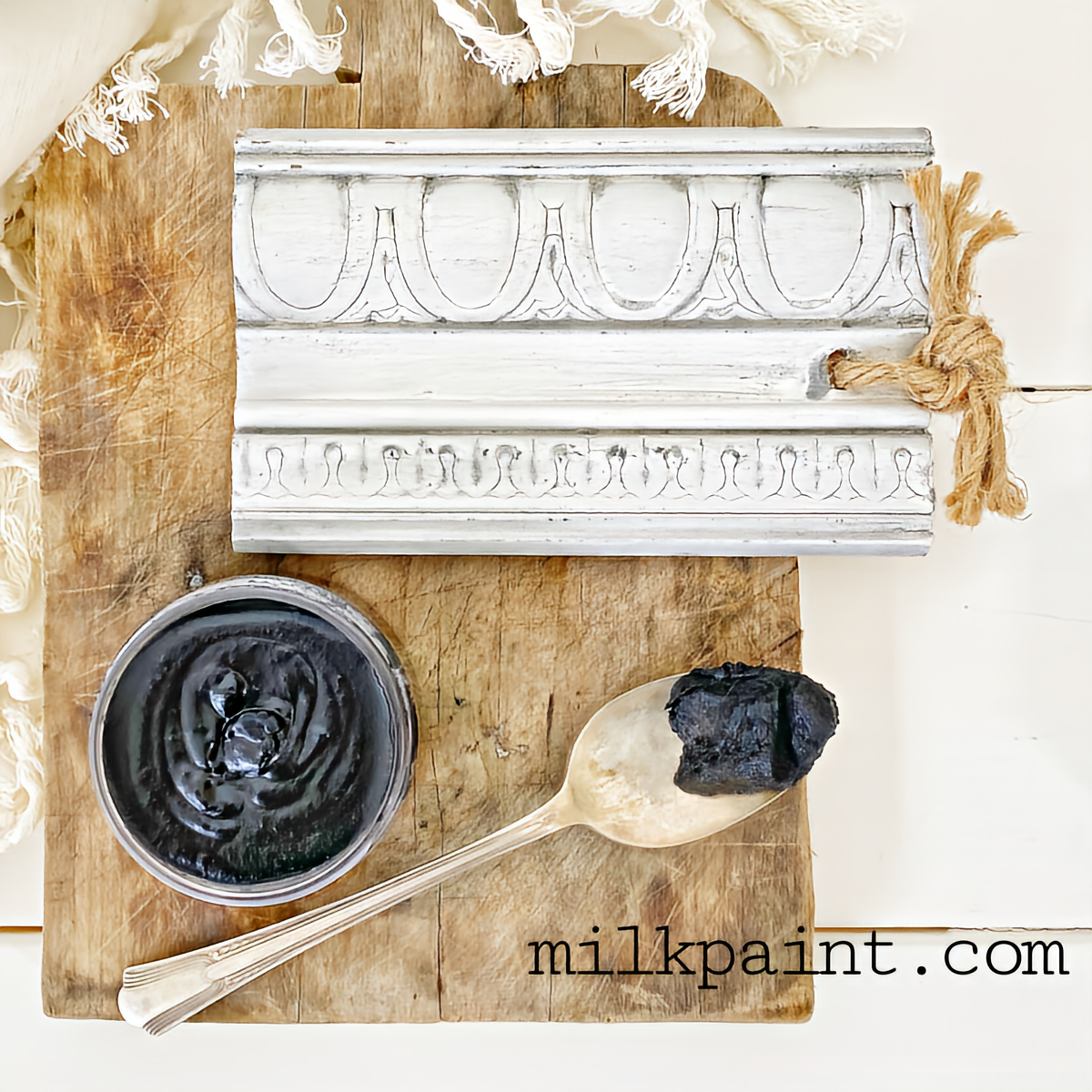 Open Black Beeswax Polish by Old Fashioned Milk Paint with spoon and wax on board, ornate trim visible.