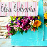 Blue wooden box painted with Old Fashioned Milk Paint Bleu Bohemia, filled with bright flowers under floral sign.