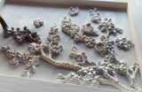 Hand painting black over raised Blossom Mould flowers by IOD on a white frame.
