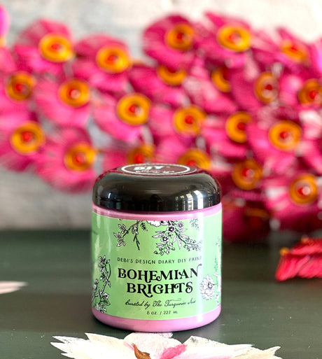 Bohemian Brights by DIY Paint Co. displayed on a table with pink flowers softly blurred in the background.