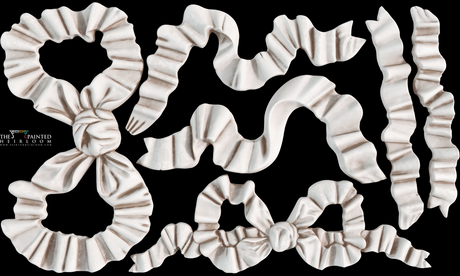 Seven white Bows Mould by I.O.D. ribbon pieces arranged on a black background.