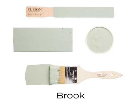 Four paint samples and a brush with Brook, a soft green acrylic by Fusion Mineral Paint.