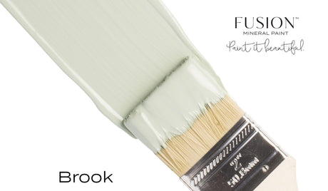 Paintbrush with Brook Fusion Mineral Paint by Fusion Mineral Paint on a plain white background.