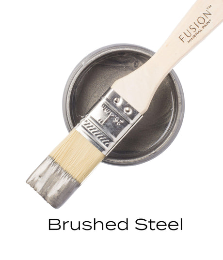 Open can of Fusion Mineral Paint in Brushed Steel Metallic with a brush resting across the top.