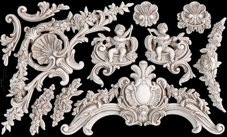 White cherubs and carvings made with I.O.D. Cadré Mould by Iron Orchid Designs on a black background.