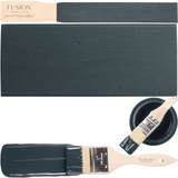 Cambridge Fusion Mineral Paint in dark blue with open can, painted sample, and wooden brush beside and inside can.