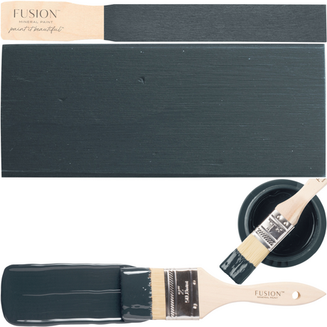 Cambridge Fusion Mineral Paint in dark blue with open can, painted sample, and wooden brush beside and inside can.