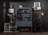 Dark blue hutch painted in Cambridge Fusion Mineral Paint, featuring dishes and flowers.