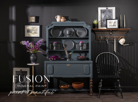 Dark blue hutch painted in Cambridge Fusion Mineral Paint, featuring dishes and flowers.