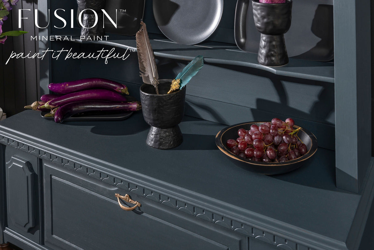 Dark blue cabinet painted with Cambridge Fusion Mineral Paint, displaying grapes, eggplants, a bowl, and two feathers.