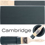 Cambridge Fusion Mineral Paint dark blue-gray rectangular swatch with paintbrushes and a small bowl nearby.