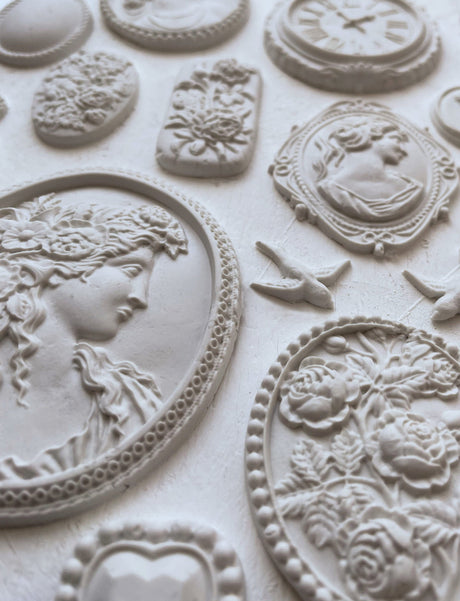 White florals and cameos made with I.O.D. Cameos Mould and air dry clay, showing ornate detailing.