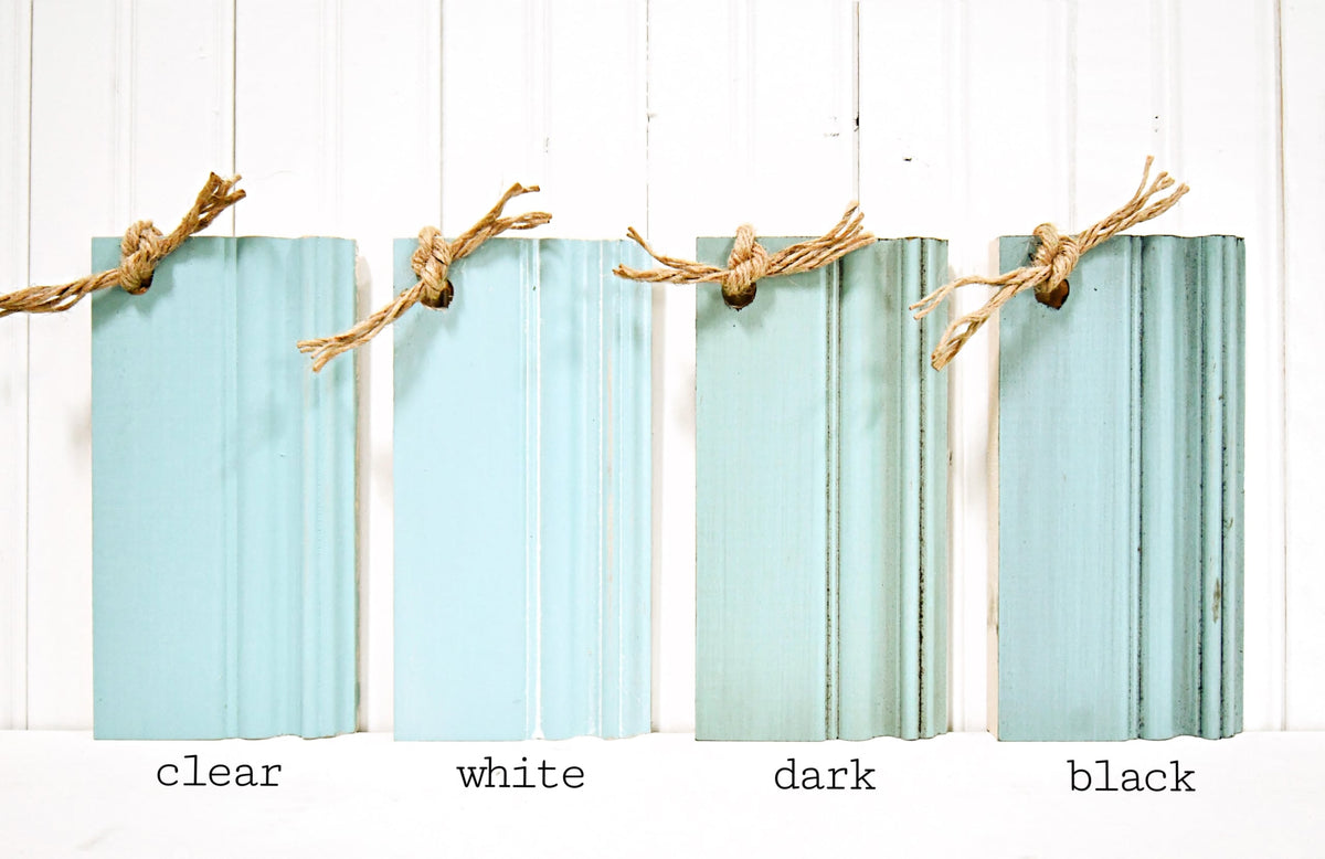 Old Fashioned Milk Paint Capri wood samples in blue/green tones with rope, labeled clear, white, dark, and black.