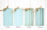 Old Fashioned Milk Paint Capri wood samples in blue/green tones with rope, labeled clear, white, dark, and black.