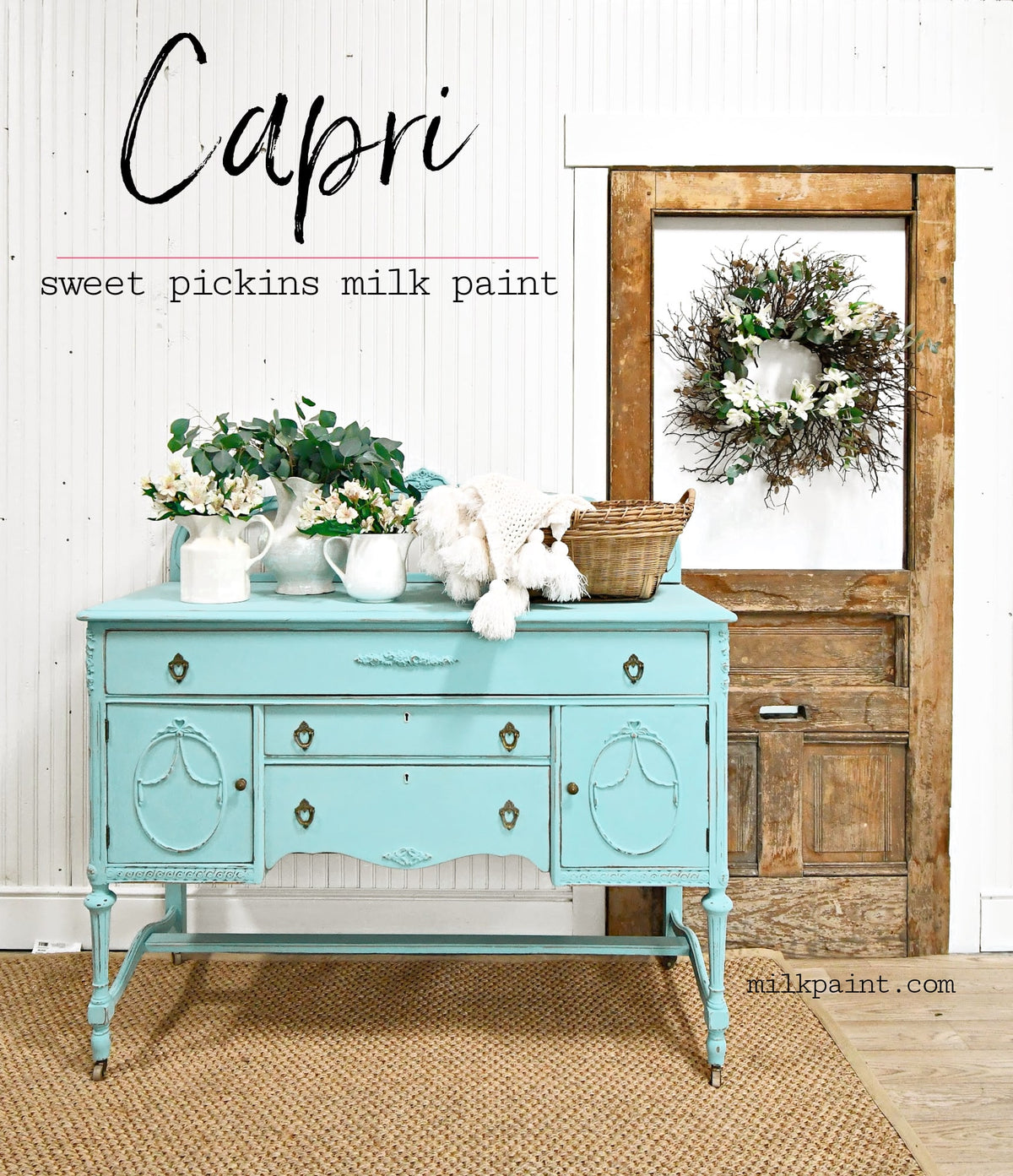 Vintage dresser painted in Old Fashioned Milk Paint’s Capri, placed near a door with a wreath and “Capri” sign above.