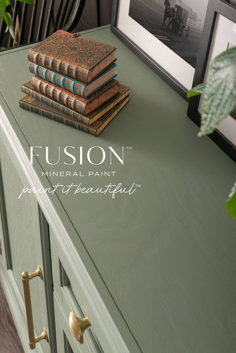 Carriage House Fusion Mineral Paint cabinet with gold handles, styled with vintage books and framed photos.