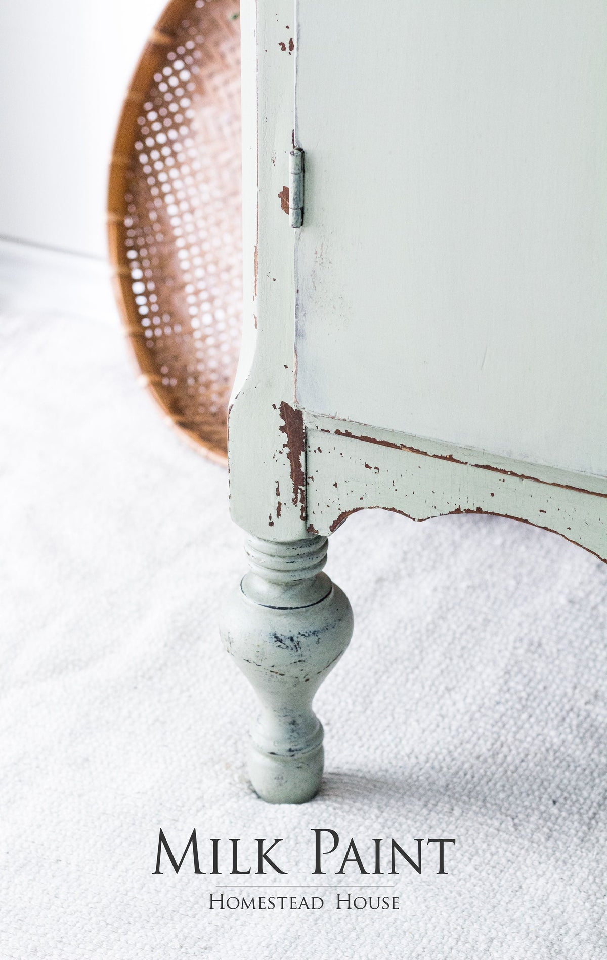 Distressed pale green table leg with Cartier Milk Paint by Homestead House branding below.