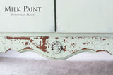 Distressed pale green cabinet with “Cartier Milk Paint by Homestead House” text.