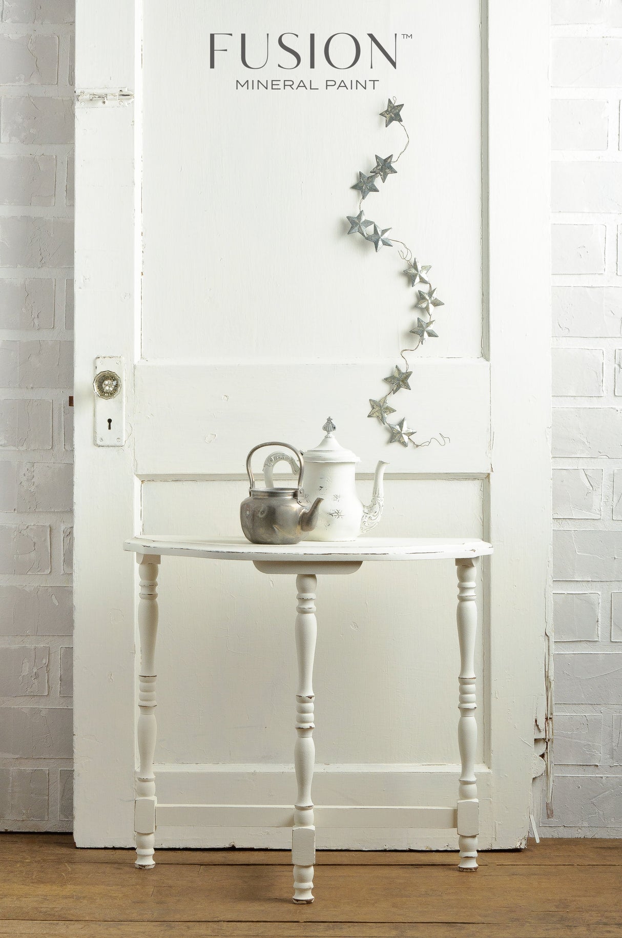 White table with teapots and a star garland, in front of a Casement by Fusion Mineral Paint wall.