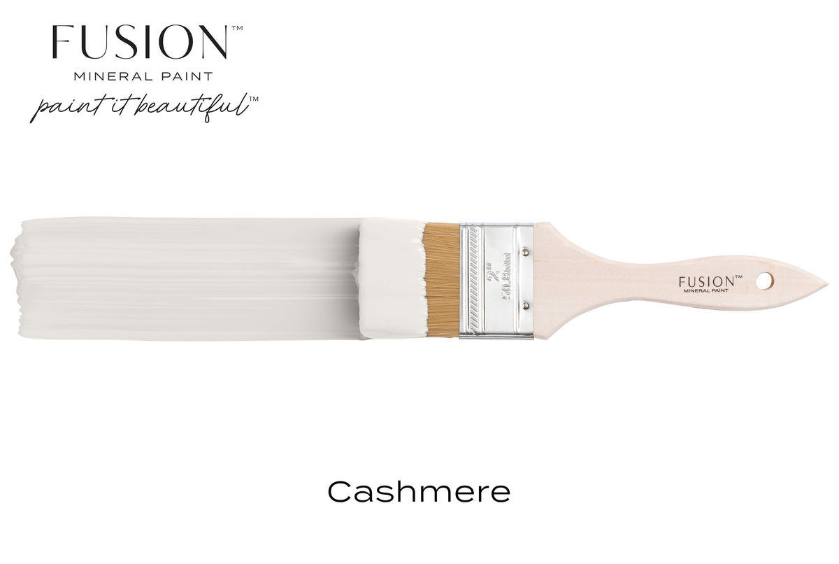 Paintbrush with Fusion Mineral Paint in Cashmere matte finish on a plain background.