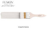 Paintbrush with Fusion Mineral Paint in Cashmere matte finish on a plain background.