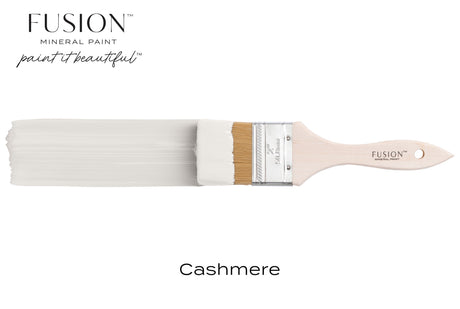 Paintbrush with Fusion Mineral Paint in Cashmere matte finish on a plain background.