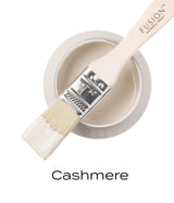 Brush dipped in Cashmere Fusion Mineral Paint, pale cream color, shown for finish and color accuracy.