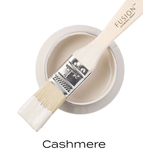 Brush dipped in Cashmere Fusion Mineral Paint, pale cream color, shown for finish and color accuracy.