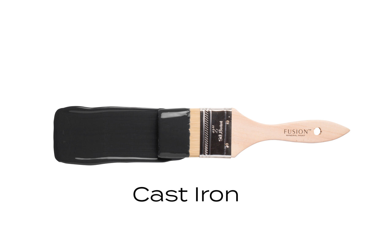 Paintbrush with bristles dipped in Fusion Mineral Paint Cast Iron against a white background.