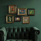 Six framed Catharina Transfers by I.O.D. displayed above a green velvet tufted sofa against a green wall.