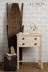 Small table painted in Fusion’s Cathedral Taupe, displayed with vintage irons and sled.