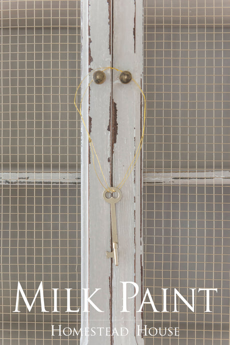 Vintage key hanging on white wire mesh cabinet finished in Cathedral Taupe Milk Paint by Homestead House.