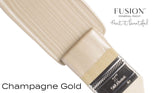 Brush with Champagne Gold Metallic Fusion Mineral Paint, shimmering on a white background.