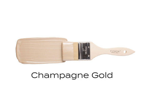 Brush tipped with Champagne Gold Metallic Fusion Mineral Paint, with shimmering paint swatch below.