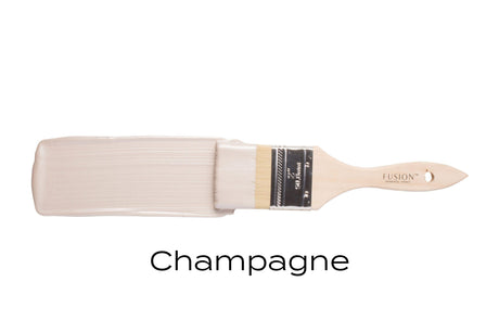 Paintbrush with Fusion Mineral Paint Champagne Metallic shown on a plain white background.