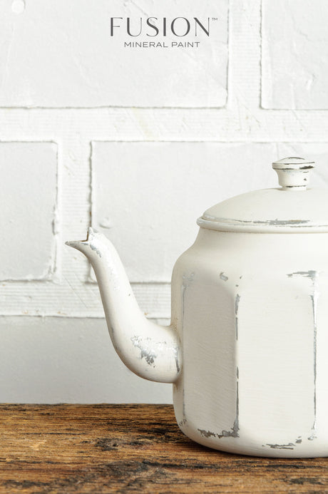 White teapot painted with Champlain Fusion Mineral Paint displayed on a wooden surface.