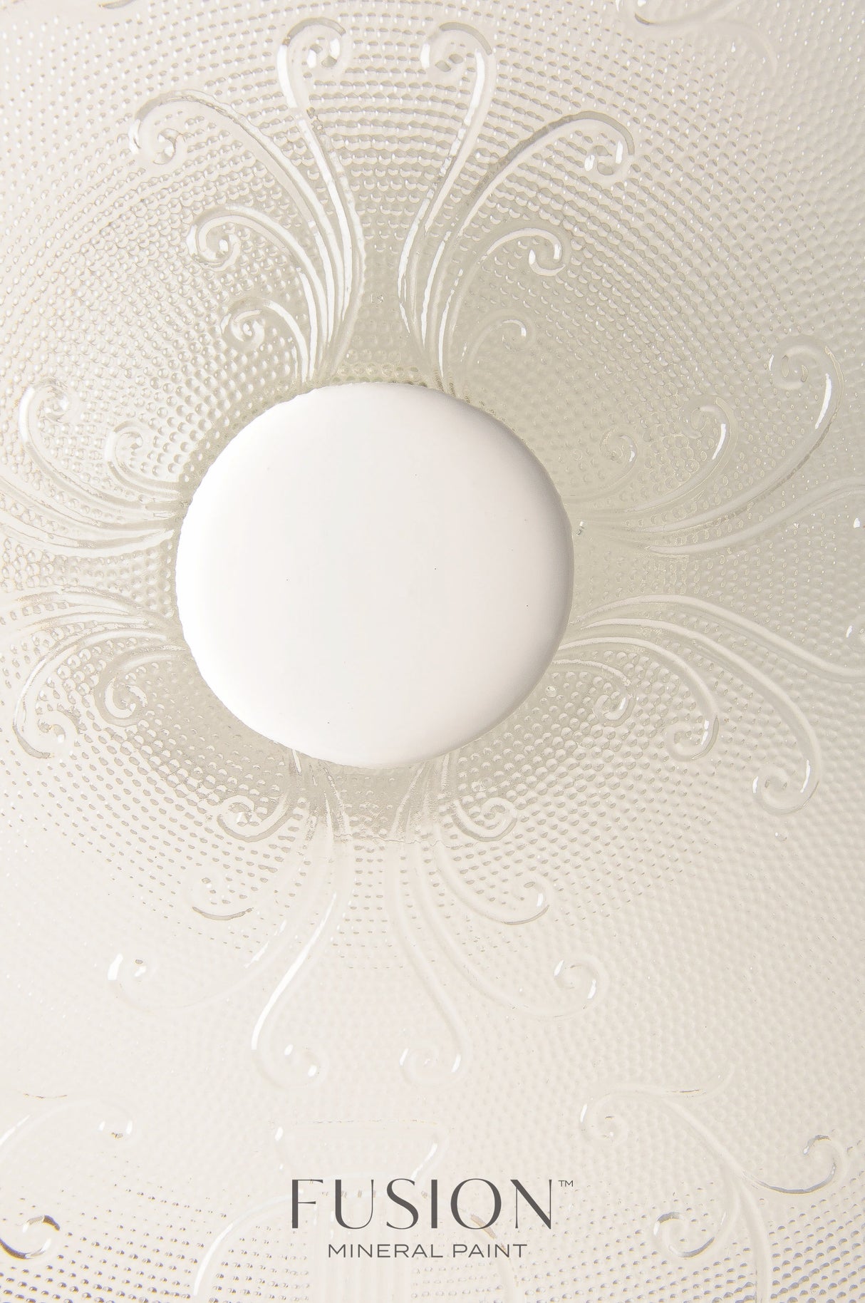 Textured glass sample with a white circle above Champlain Fusion Mineral Paint label.