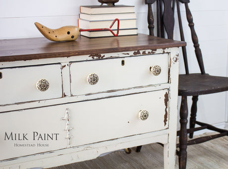 Distressed Champlain Milk Paint dresser by Homestead House with wood top, chair, books, and “Milk Paint” text.