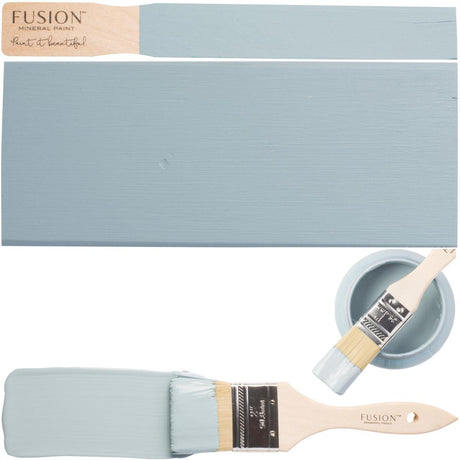 Champness Fusion Mineral Paint brush beside matte wood samples and a cup with more paint and another brush.