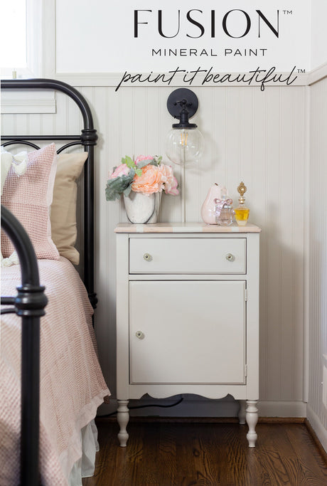 White nightstand painted in Chateau by Fusion Mineral Paint, placed beside pink bedding.