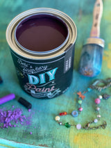Cherry Picked DIY Paint by DIY Paint Co. on wood with paintbrush, beads, and purple chalk nearby.