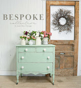 Cheshire by Old Fashioned Milk Paint mint dresser with white knobs, shown with floral pitchers.