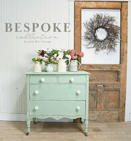 Cheshire by Old Fashioned Milk Paint mint dresser with white knobs, shown with floral pitchers.