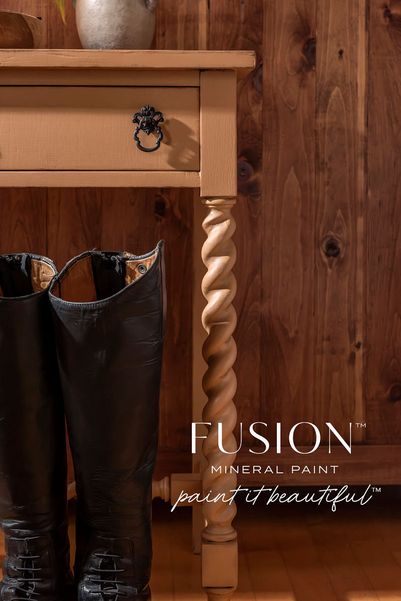 Tan table with twisted legs next to tall black boots; Chestnut Mare Fusion Mineral Paint logo at lower right.