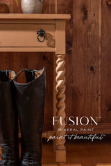 Tan table with twisted legs next to tall black boots; Chestnut Mare Fusion Mineral Paint logo at lower right.