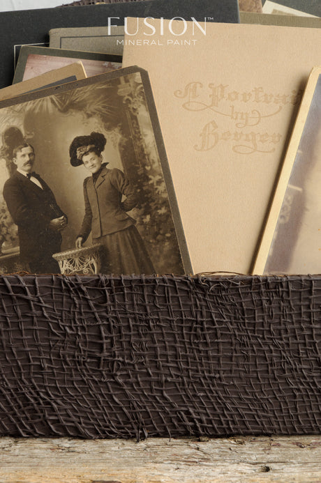 Chocolate Fusion Mineral Paint container atop stacked sepia vintage photos in a brown holder.