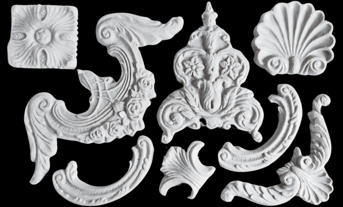 I.O.D. Classic Elements Mould white plaster ornaments displayed on a black background.