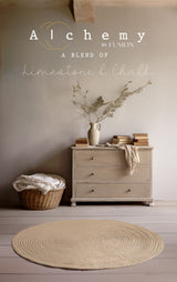 Beige rug on wood floor, basket with linens, books and vase on dresser; text above about Clay Alchemy Paint.
