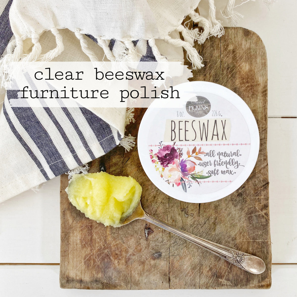 Clear Beeswax Furniture Polish by Old Fashioned Milk Paint next to wax on a board with a striped cloth nearby.