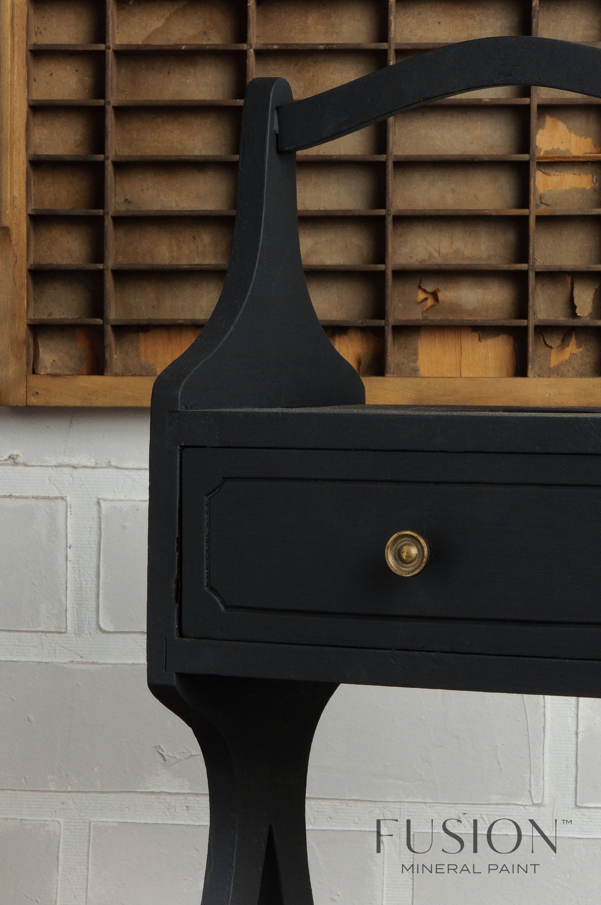 Wooden table painted in Coal Black Fusion Mineral Paint positioned in front of a wooden organizer.